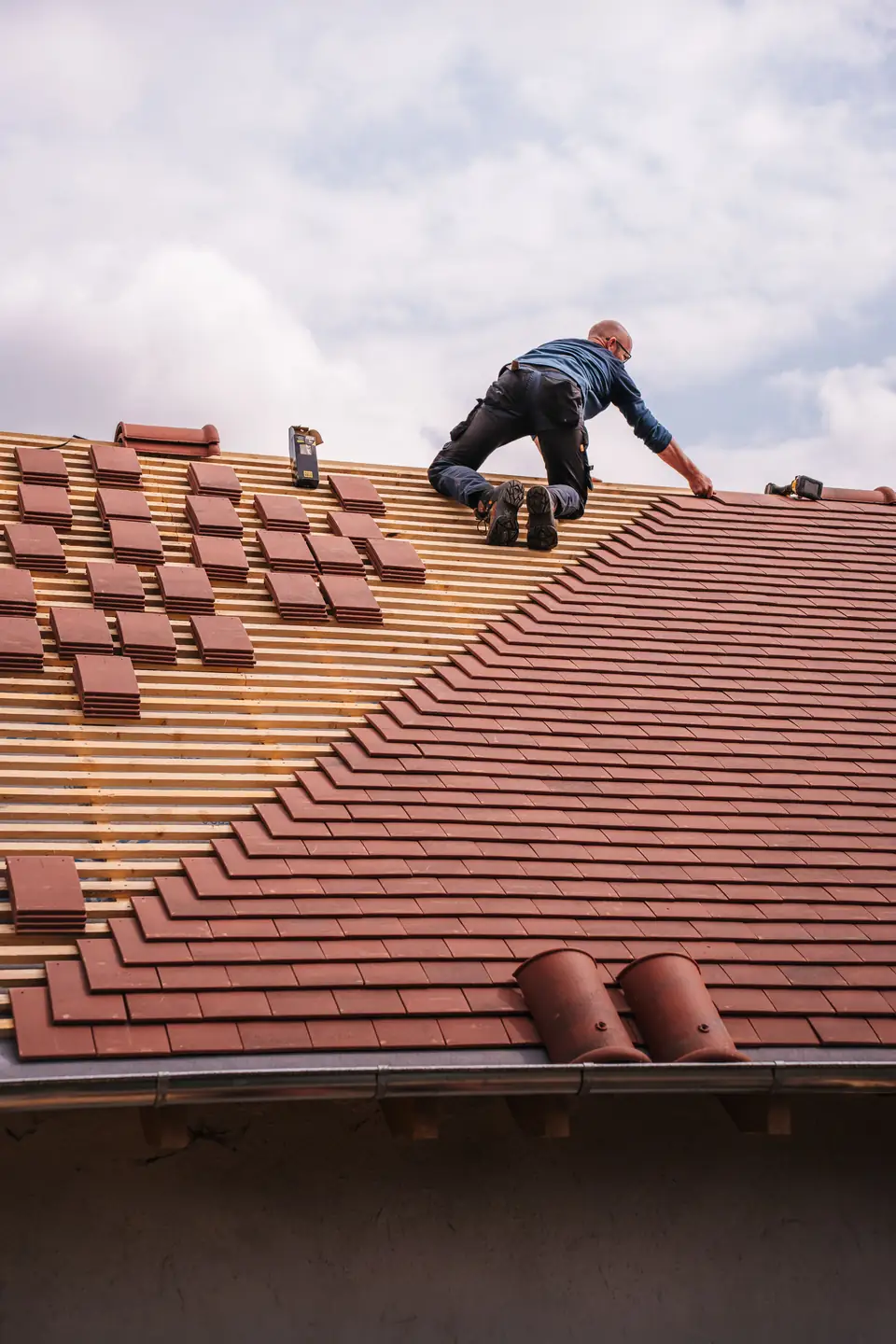Stock view of a roofer installing shingles on a residential roof