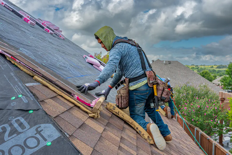 Roofers installing shingles on a home